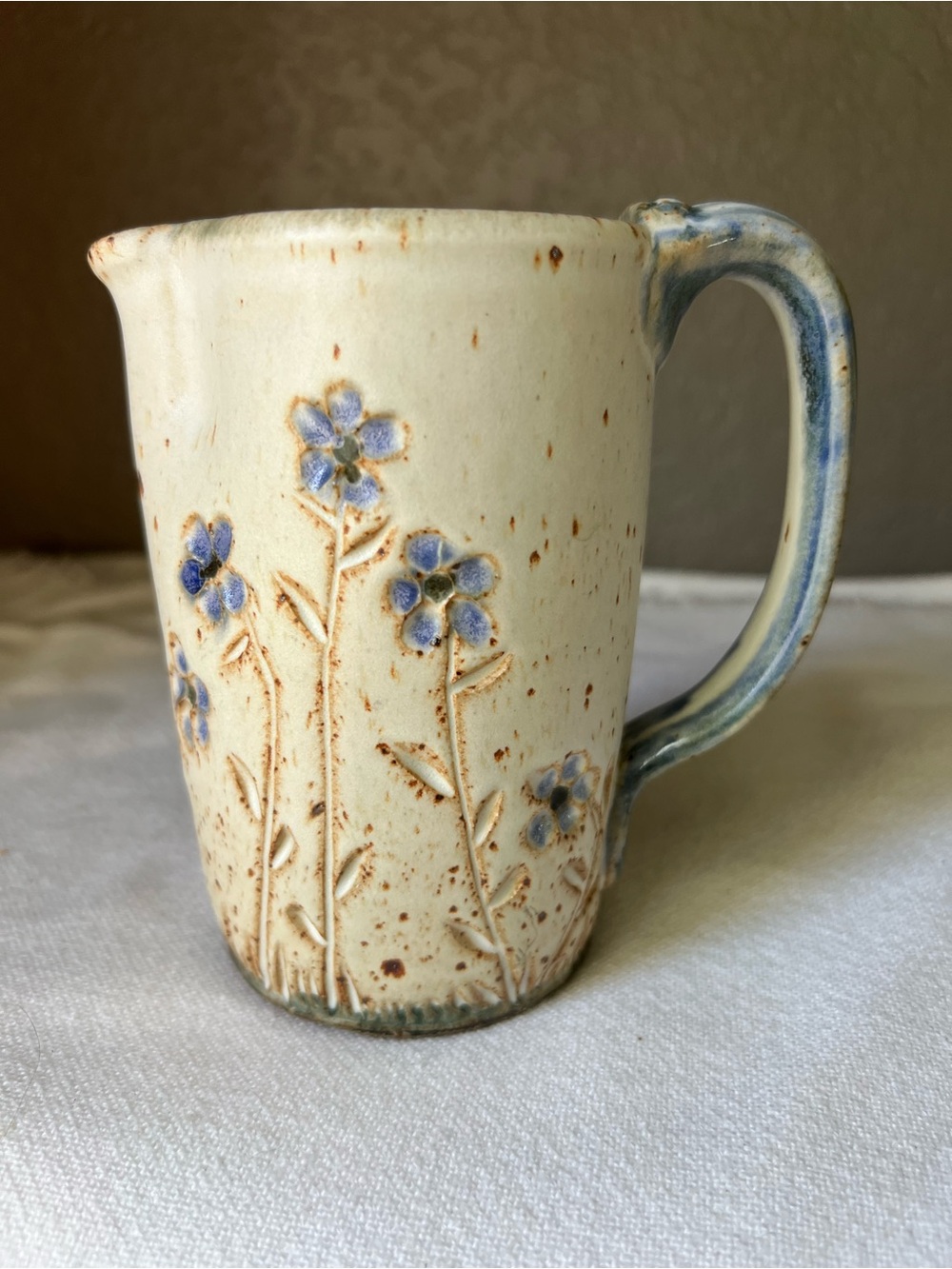 Hand crafted vintage stoneware pitcher from Alberta Pottery features blue floral